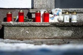 Nachbarn bringen ihre Trauer mit Kerzen und einem Teddybär zum Ausdruck.