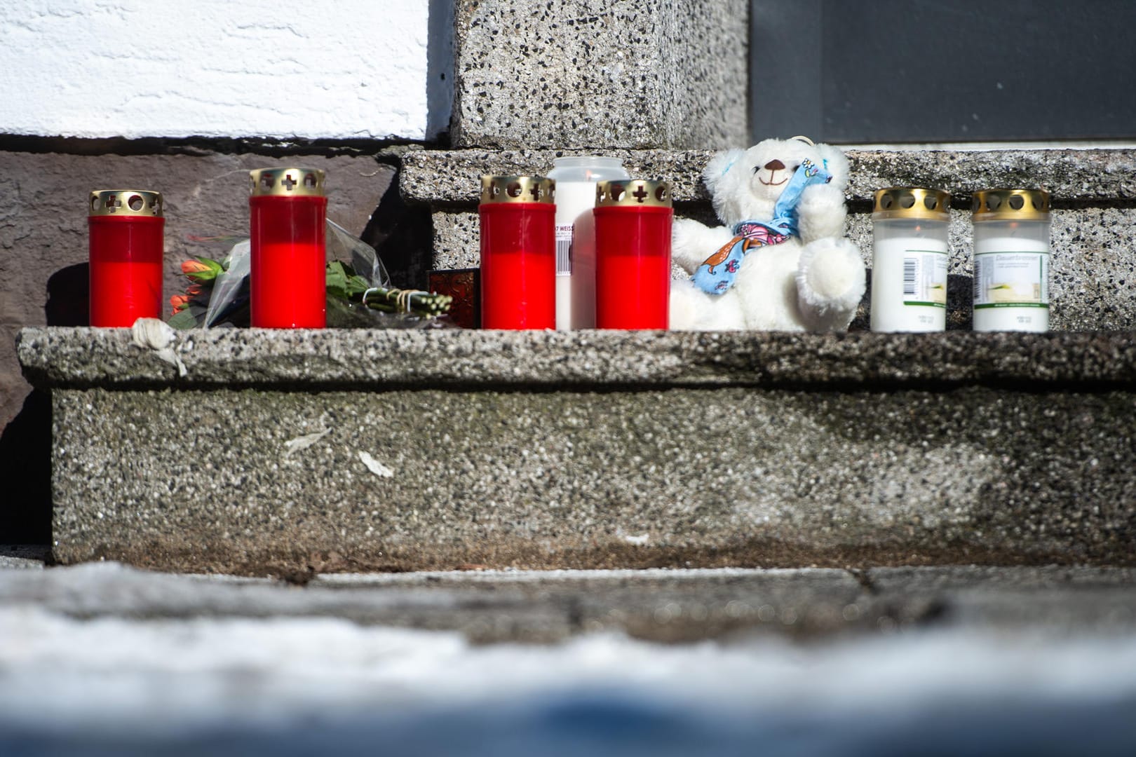 Kerzen und ein Teddybär stehen vor dem Haus an der Elberfelderstraße: Nach einem Brand am gestrigen Abend entdeckte die Feuerwehr fünf Leichen in dem Haus.