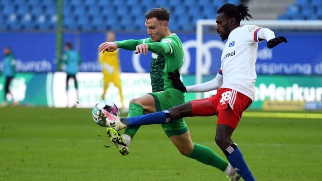 Fürths David Raum (l) und Bakery Jatta vom HSV kämpfen um den Ball.