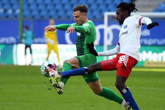 Fürths David Raum (l) und Bakery Jatta vom HSV kämpfen um den Ball.