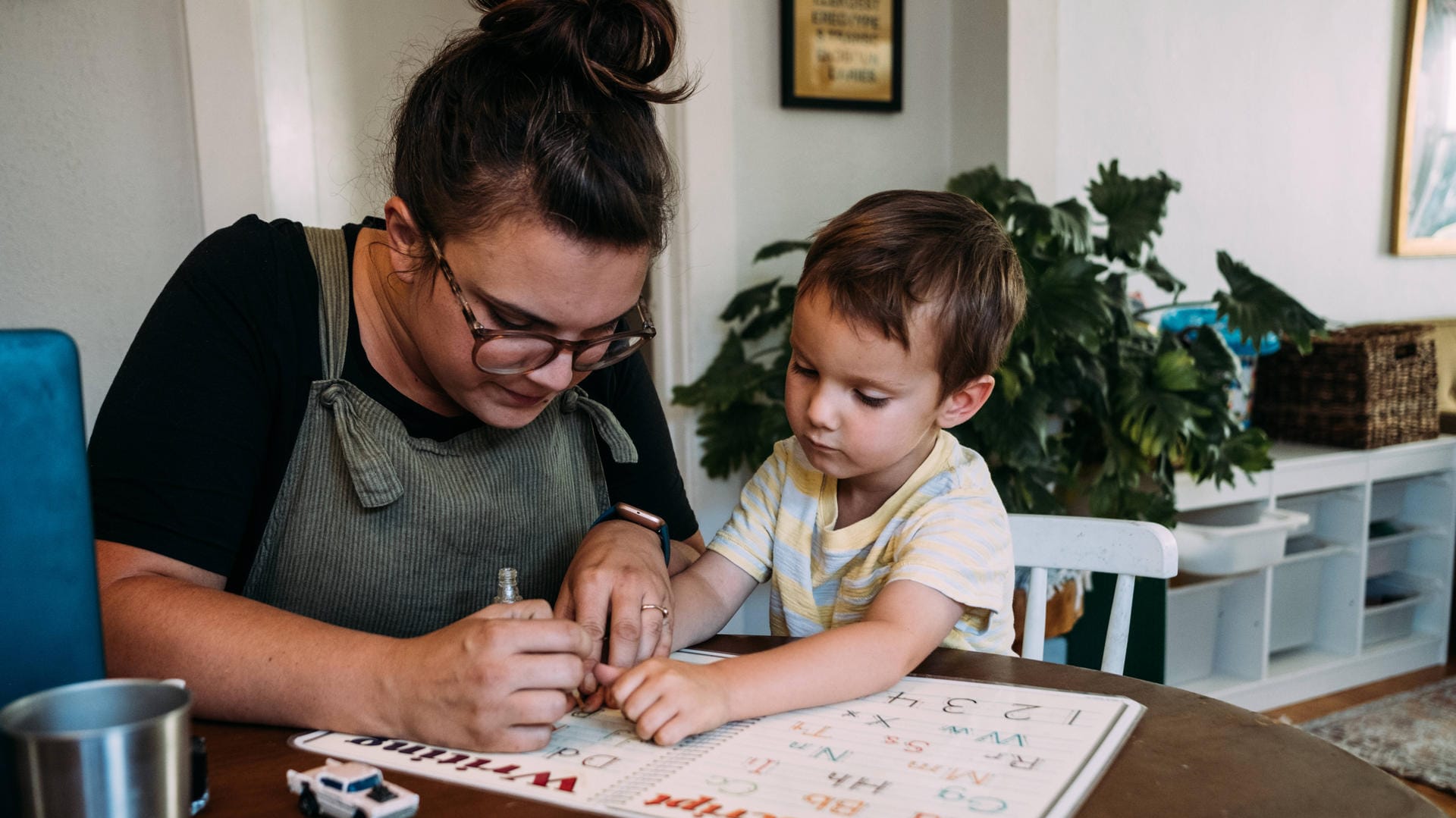 Mutter und Sohn beim Lernen zuhause: Die Kitas haben zu, Eltern müssen deswegen oft Job und Kinderbetreuung zugleich stemmen.