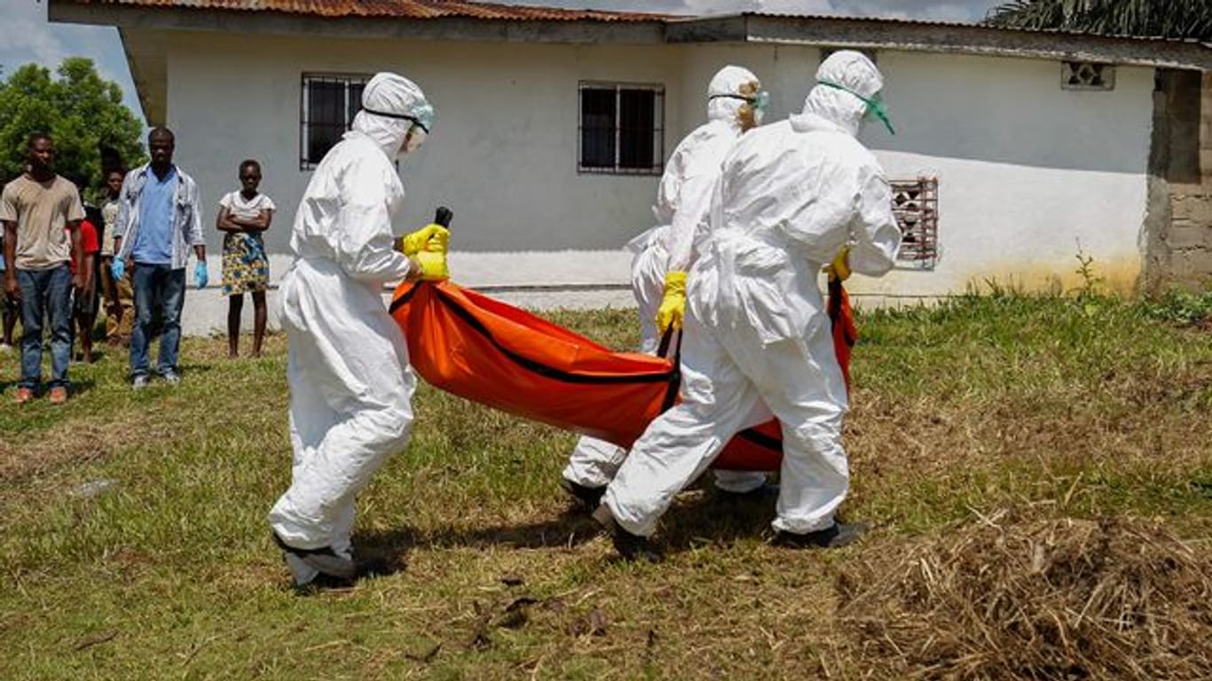 Ein Team vom Roten Kreuz trägt im Oktober 2014 in Monrovia (Liberia) ein vermutetes Ebolaopfer in einem speziellen Leichensack.