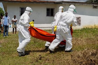 Ein Team vom Roten Kreuz trägt im Oktober 2014 in Monrovia (Liberia) ein vermutetes Ebolaopfer in einem speziellen Leichensack.