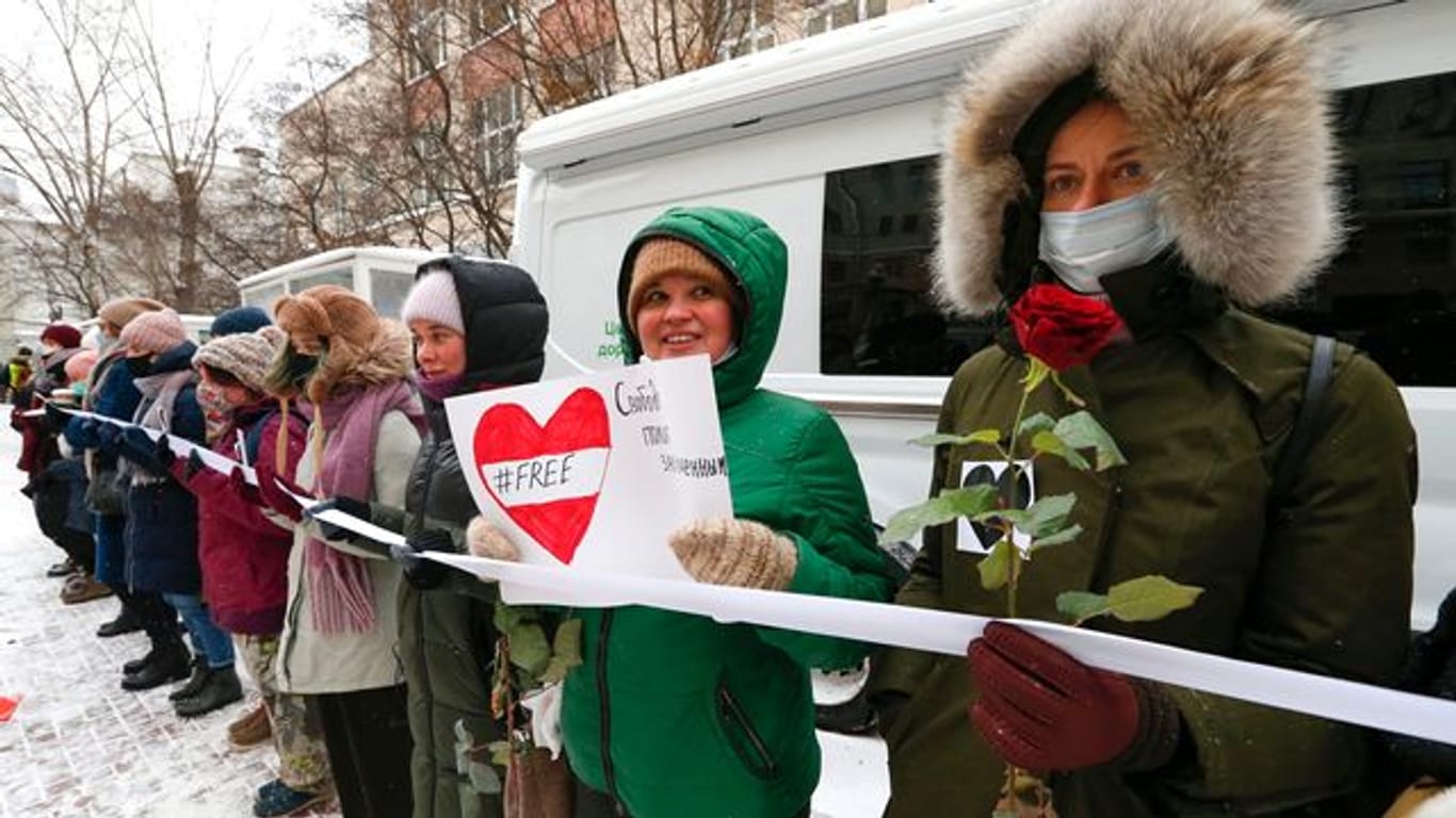 Während einer Kundgebung in Moskau halten Teilnehmer ein Band und bilden eine Menschenkette.