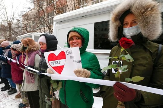 Während einer Kundgebung in Moskau halten Teilnehmer ein Band und bilden eine Menschenkette.