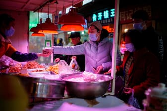 Einkauf mit Maske auf einem Lebensmittelmarkt in Wuhan: WHO-Forscher wollen 72.000 Corona-Verdachtsfälle aus der Zeit vor Dezember 2019 untersuchen.