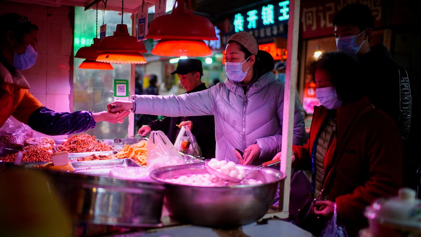 Einkauf mit Maske auf einem Lebensmittelmarkt in Wuhan: WHO-Forscher wollen 72.000 Corona-Verdachtsfälle aus der Zeit vor Dezember 2019 untersuchen.