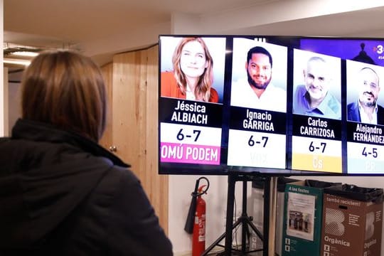 Eine Journalistin beobachtet die ersten Hochrechnungsergebnisse in der Parteizentrale von En Comu Podem.