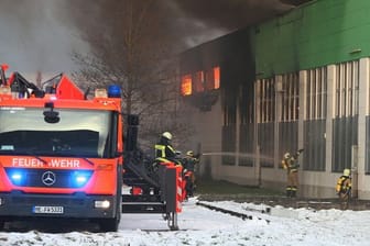 Feuerwehrleute bekämpfen den Großbrand in der Lagerhalle in Hilden: Immer wieder war das Löschwasser gefroren.
