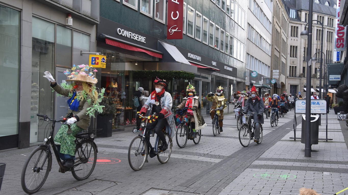 Eine Gruppe von kostümierten Karnevalisten fährt mit dem Fahrrad am Karnevalssonntag durch die Kölner Innenstadt: Viele Jecken in den Karnevalshochburgen wollten trotz Corona Karneval feiern. Manche verstießen dabei gegen Corona-Auflagen.