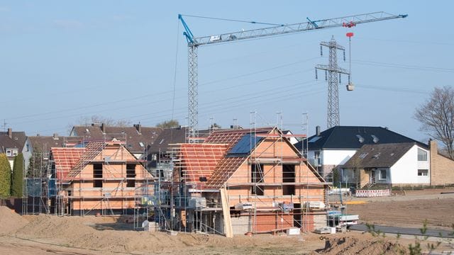 Einfamilienhäuser stehen im Rohbau in einem Neubaugebiet in der Region Hannover.