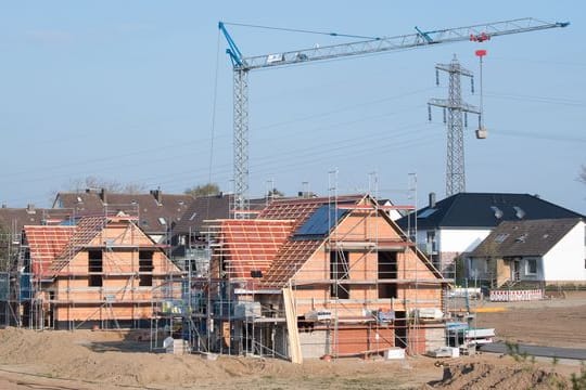 Einfamilienhäuser stehen im Rohbau in einem Neubaugebiet in der Region Hannover.