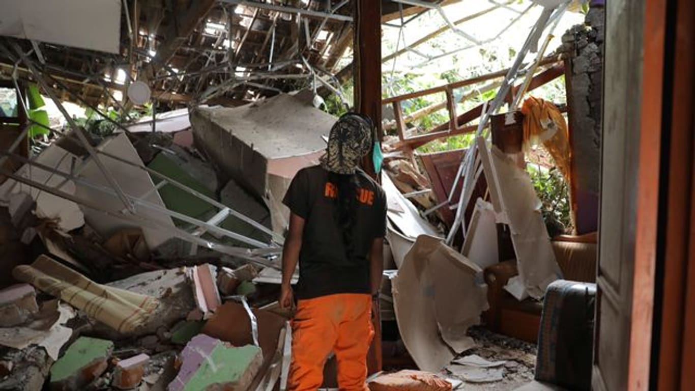 Ein Rettungshelfer inspiziert ein zerstörtes Haus im Dorf Nganjuk.