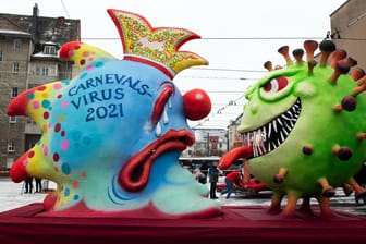 Ein Mottowagen auf dem das Coronavirus dem Carnevalsvirus die Zuge rausstreckt: Pandemiebedingt sollten die Karikaturen nicht als Zug, sondern getrennt voneinander durch die Stadt rollen.