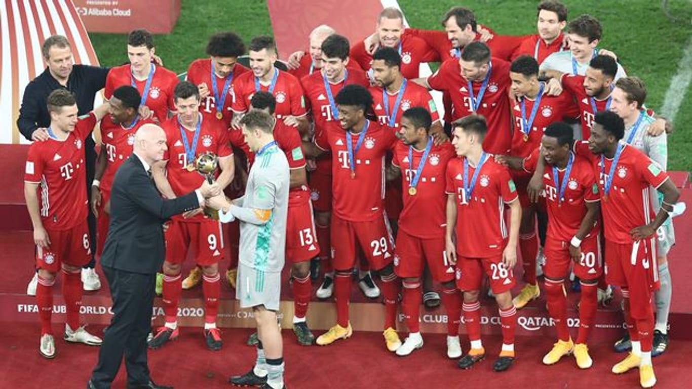 FIFA-Boss Gianni Infantino (l) überreicht Bayern-Kapitän Manuel Neuer den Pokal der Club-WM.