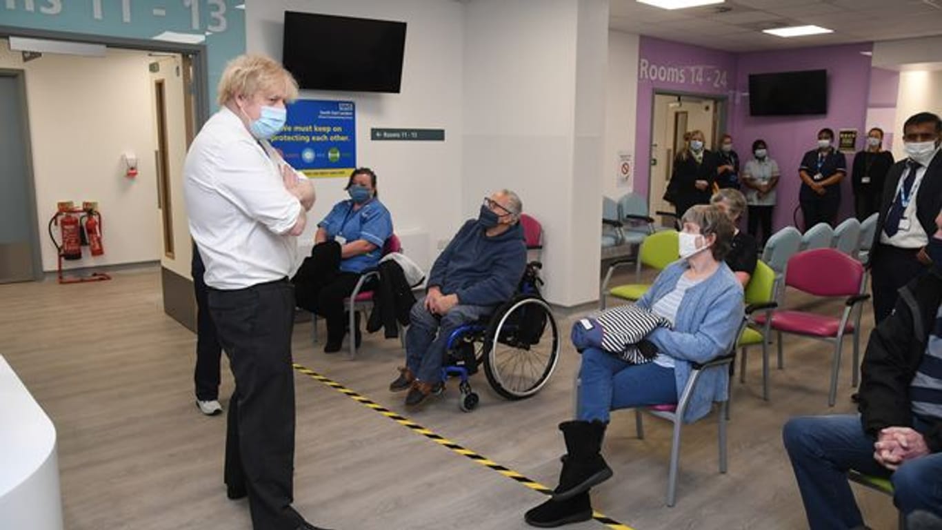 Der britische Premier Boris Johnson (l) bei einem Besuch eines Corona-Impfzentrums in London.