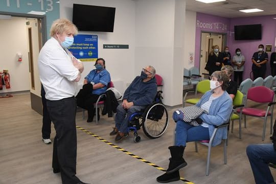 Der britische Premier Boris Johnson (l) bei einem Besuch eines Corona-Impfzentrums in London.