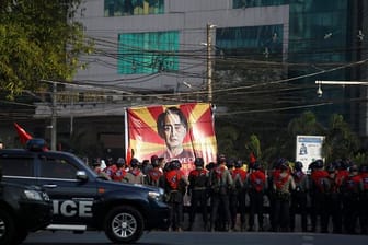 Polizisten stehen in Rangun vor Teilnehmern eines Protestes gegen den jüngsten Militärputsch.
