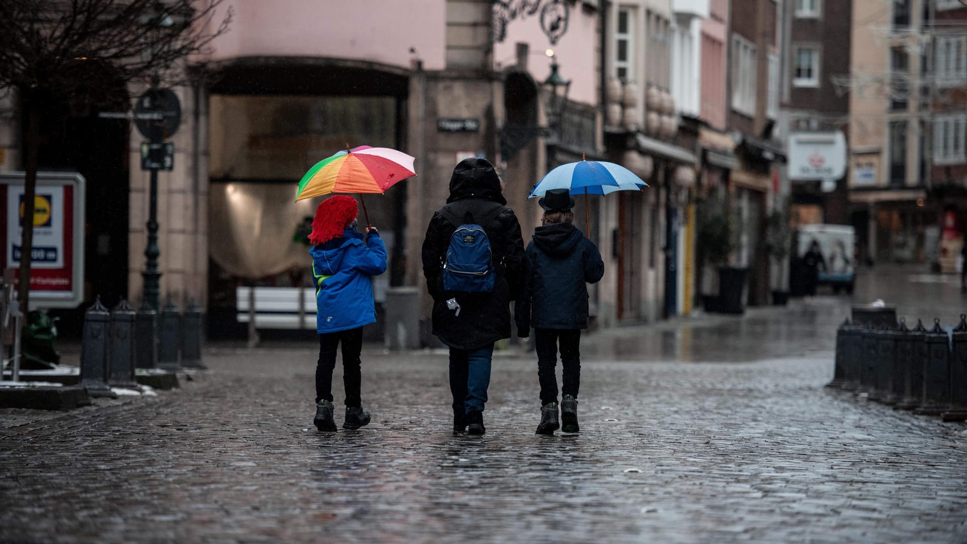 Zwei Jungen laufen verkleidet durch den Regen in der Düsseldorfer Altstadt: Coronabedingt ist der klassische Zug durch die Stadt dieses Jahr ausgefallen.