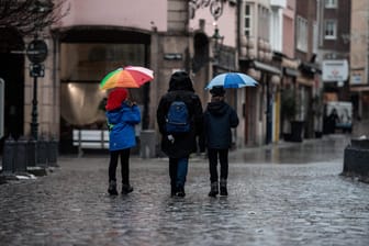 Zwei Jungen laufen verkleidet durch den Regen in der Düsseldorfer Altstadt: Coronabedingt ist der klassische Zug durch die Stadt dieses Jahr ausgefallen.
