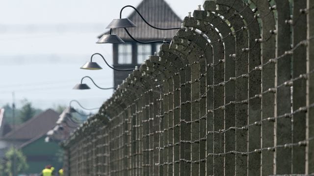 Stacheldrahtzäune und ein Wachturm auf dem Gelände des ehemaligen Vernichtungslagers Auschwitz-Birkenau.
