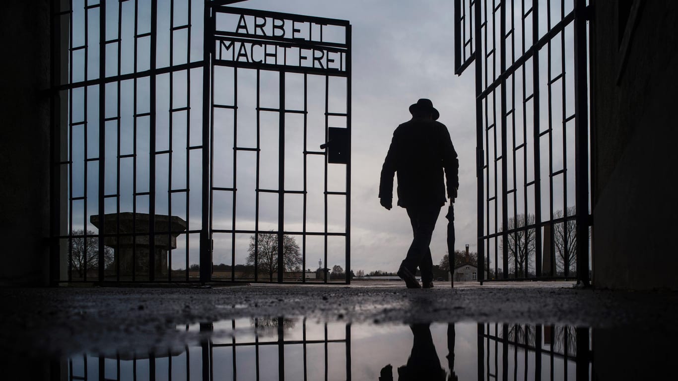 Mann geht durch das Tor des KZ Sachsenhausen: Aktuell ist ein ehemaliger Wachmann des Lagers angeklagt – im Alter von 100 Jahren (Symbolbild).