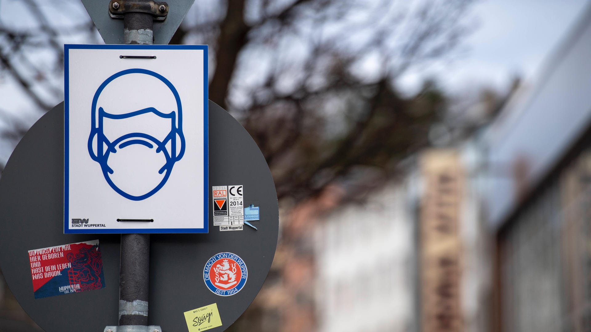 Ein Schild weist auf die Maskenpflicht in der Fußgängerzone von Wuppertal hin (Archivbild): In der Stadt ist die Inzidenz weiter hoch.