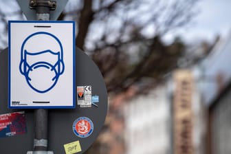 Ein Schild weist auf die Maskenpflicht in der Fußgängerzone von Wuppertal hin (Archivbild): In der Stadt ist die Inzidenz weiter hoch.