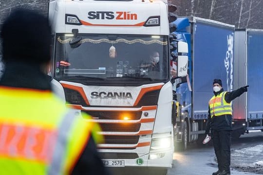 Polizisten kontrollieren auf einem Parkplatz kurz nach der deutsch-tschechischen Grenze Fahrzeuge.