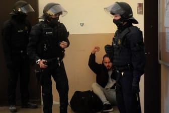 Rapper Pablo Hasél hebt bei seiner Festnahme in der Universität von Lleida die Faust.