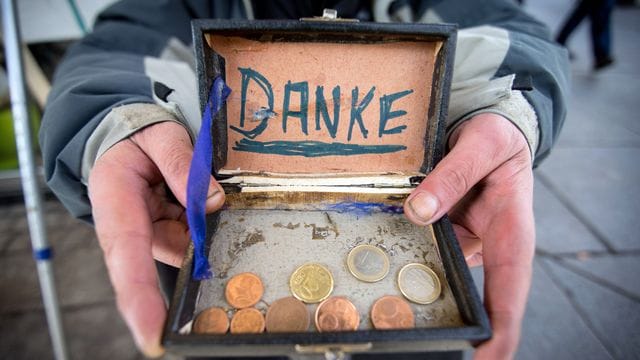 Ein Bettler bedankt sich in der Fußgängerzone für Geldspenden. Ein Bettler bedankt sich in der Fußgängerzone für Geldspenden.