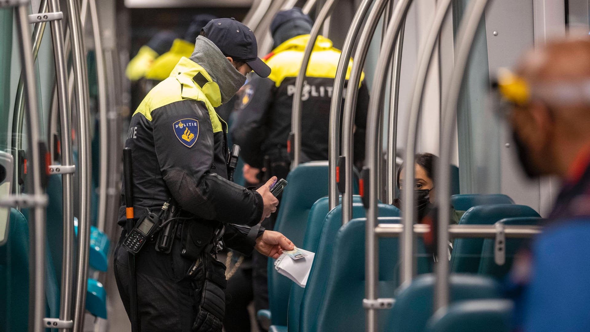 Niederländische Polizisten kontrollieren die Ausgangssperre in der Straßenbahn: Wer keine schriftlichen Belege zur Aufhebung der Ausgangssperre parat hat, muss 95 Euro bezahlen. Niederländische Polizisten kontrollieren die Ausgangssperre in der Straßenbahn: Wer keine schriftlichen Belege zur Aufhebung der Ausgangssperre parat hat, muss 95 Euro bezahlen.