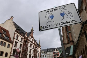 Ein Schild weist in Leipzig auf die Maskenpflicht hin (Archivbild): In Sachsen und in Leipzig nimmt der Corona-Inzidenz langsam ab.