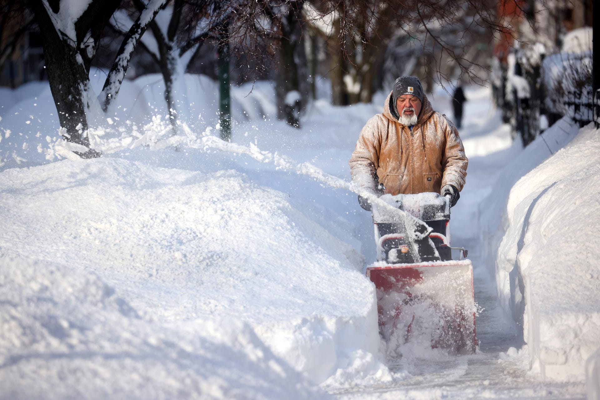 Ein Mann in Chicago befreit den Bürgersteig vom Schnee: Vor allem in der Stadt türmen sich nach dem Wintersturm Uri Schneemassen.