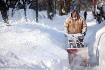 Ein Mann in Chicago befreit den Bürgersteig vom Schnee: Vor allem in der Stadt türmen sich nach dem Wintersturm Uri Schneemassen.