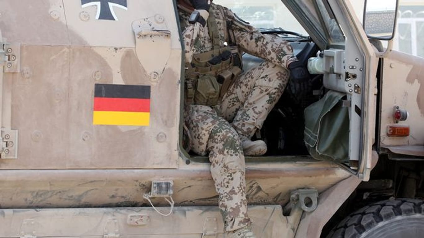 Ein Soldat der Bundeswehr sitzt auf dem Gelände des Police-Trainings-Camps in Kundus in einem gepanzerten Fahrzeug Dingo.