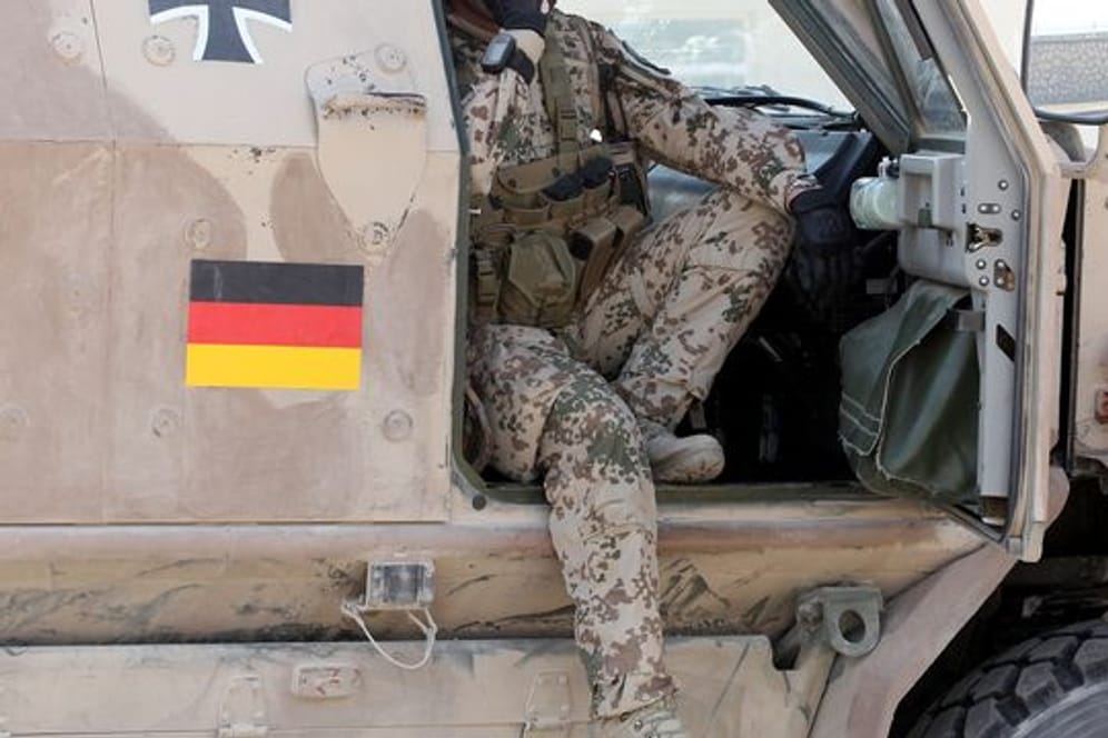 Ein Soldat der Bundeswehr sitzt auf dem Gelände des Police-Trainings-Camps in Kundus in einem gepanzerten Fahrzeug Dingo.