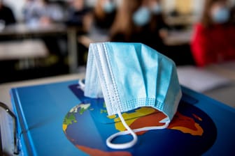 Eine Schutzmaske liegt in einer Schulklasse: Das Robert-Koch-Institut hat am Donnerstag wieder mehr als 10.000 Corona-Neuinfektionen gemeldet.