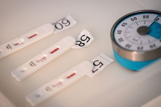 15 Minuten bis zum Ergebnis: Antigen-Testkassetten für den Corona-Schnelltest liegen neben einer Stoppuhr.
