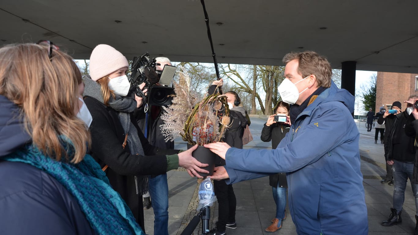 Ein Strauß aus Trockenblumen wird gemeinsam mit den Unterschriften aus der Petition an OB Ulf Kämpfer übergeben.