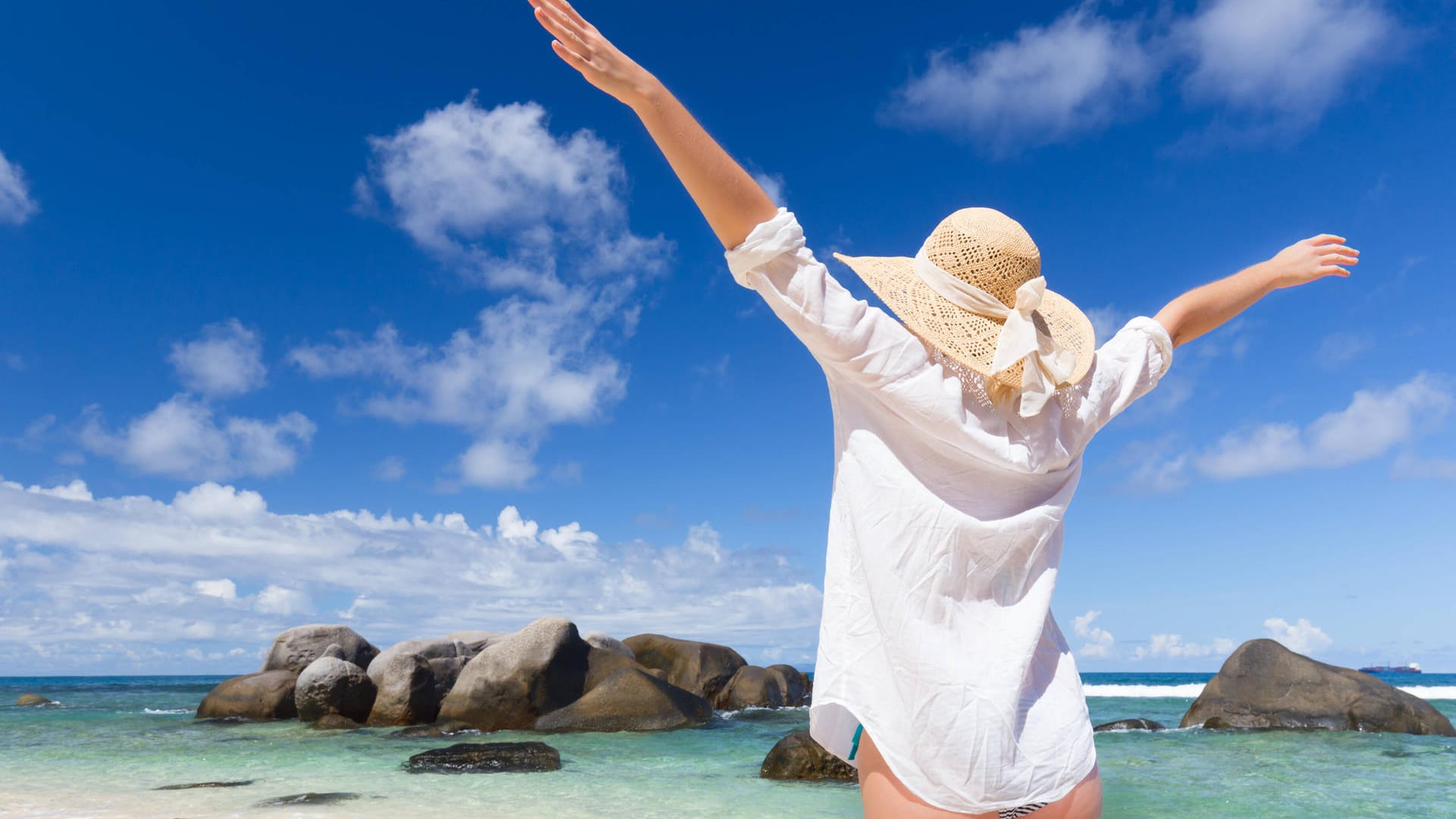 Eine Frau genießt das Meer auf den Seychellen (Archivbild). Die Insel gehört zu den Urlaubsgebieten, die jetzt erste Lockerungen für Touristen ankündigen.