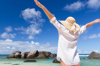 Eine Frau genießt das Meer auf den Seychellen (Archivbild). Die Insel gehört zu den Urlaubsgebieten, die jetzt erste Lockerungen für Touristen ankündigen.