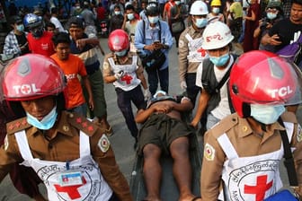 Helfer des Roten Kreuzes tragen einen Verletzten von einer Demonstration gegen den Putsch weg.