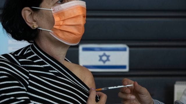 Eine Frau erhält in einem Impfzentrum in Tel Aviv eine Impfung. Eine Frau erhält in einem Impfzentrum in Tel Aviv eine Impfung.