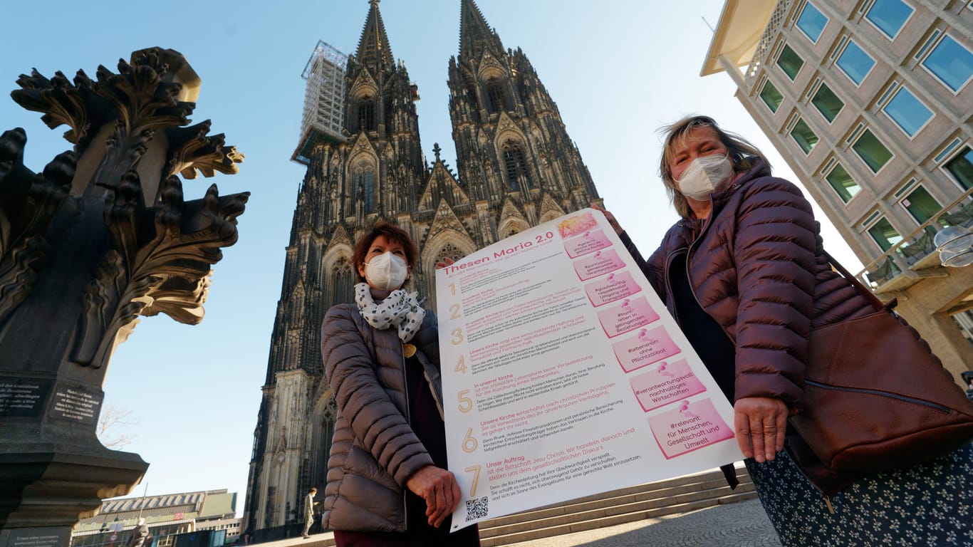 Aktivistinnen der der katholischen Reforminitiative "Maria 2.0" stehen mit einem Thesenpapier vor dem Kölner Dom: Sie fordern unter anderem eine geschlechtergerechte Kirche.