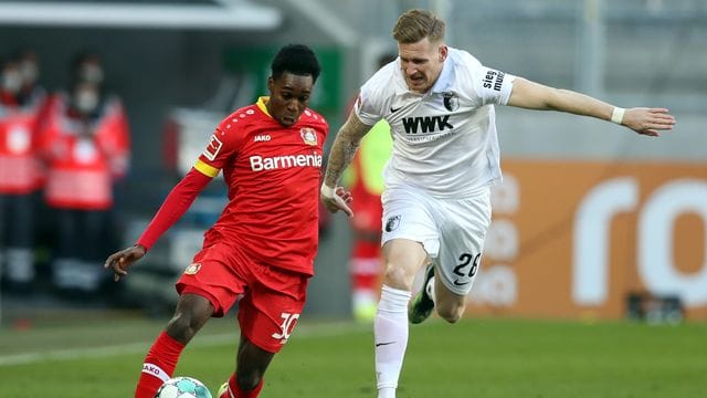 Leverkusens Jeremie Frimpong (l) und Augsburgs Andre Hahn im Zweikampf um den Ball. Leverkusens Jeremie Frimpong (l) und Augsburgs Andre Hahn im Zweikampf um den Ball.