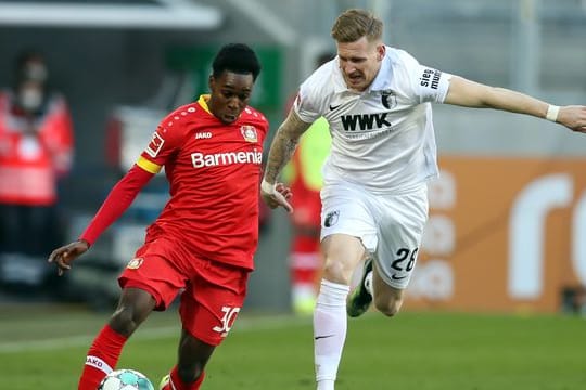Leverkusens Jeremie Frimpong (l) und Augsburgs Andre Hahn im Zweikampf um den Ball.