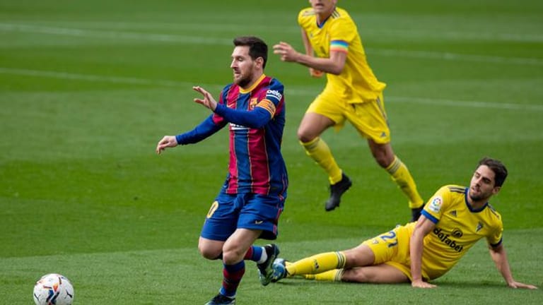 Lionel Messi (l) kam mit dem FC Barcelona gegen den FC Cadiz lediglich zu einem Remis.