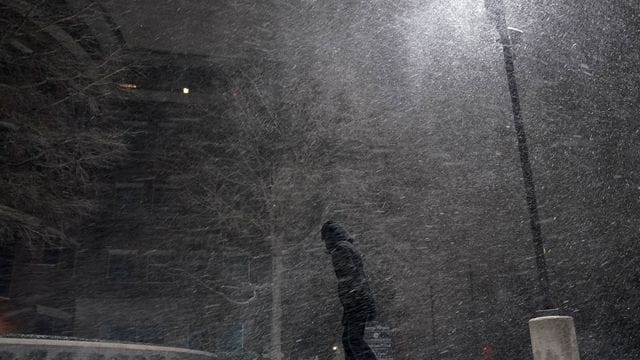 Eine Frau geht im texanischen San Antonio durch den fallenden Schnee.