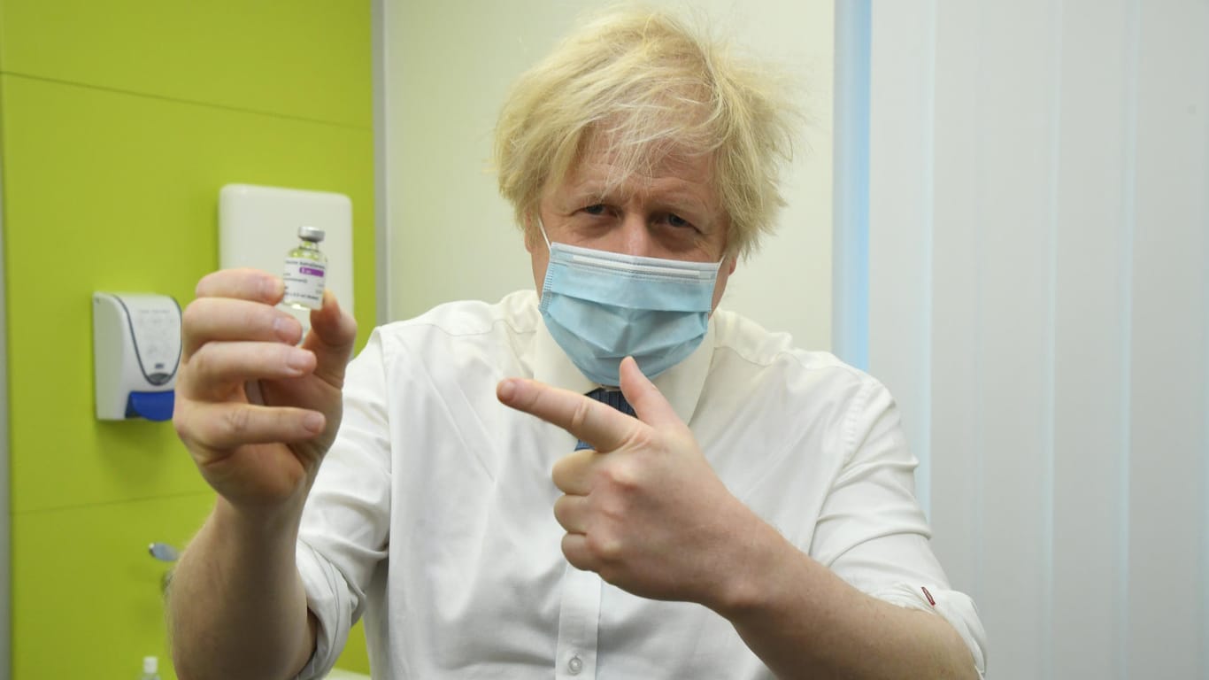 Boris Johnson, Premierminister von Großbritannien zeigt auf ein Fläschchen mit Impfstoff von Astrazeneca: Seine Impfstoffkampagne war ein voller Erfolg.